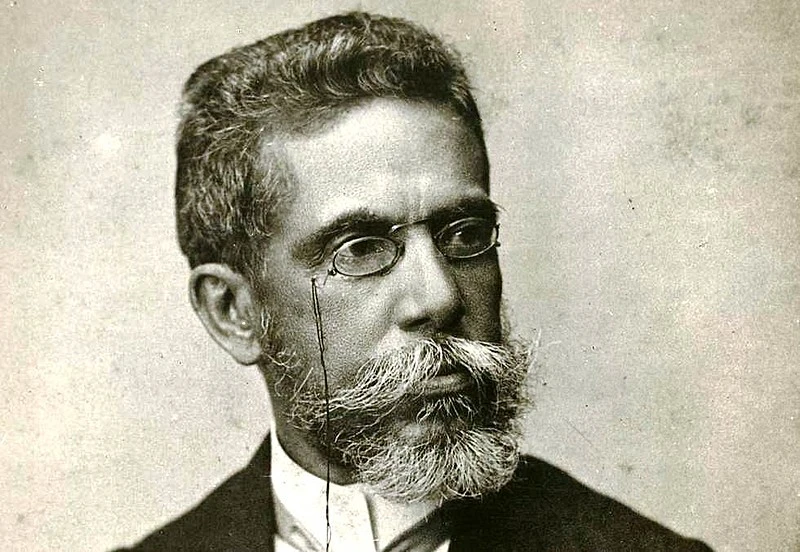 Escritor Machado de Assis, usando barba e óculos